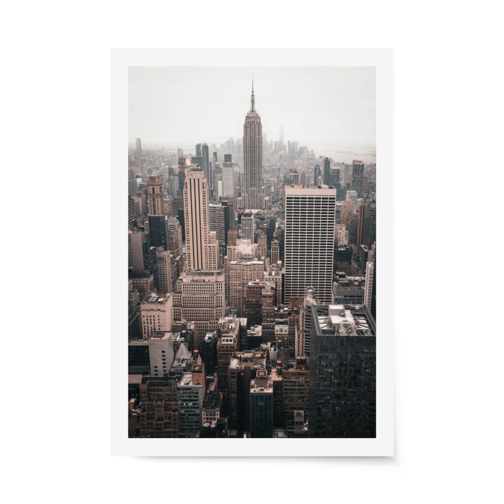 Fine art photograph of the New York City skyline with the Empire State Building centered on a hazy day, featuring warm, muted city tones.
