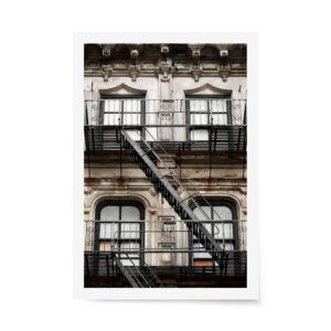 Close-up of a classic New York City building with ornate windows and a black metal fire escape staircase.