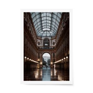 Elegant photograph of Galleria Vittorio Emanuele II in Milan with soft morning light reflecting off the polished floor beneath a glass-domed ceiling.