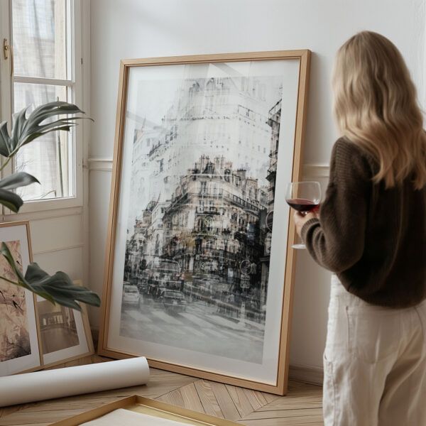 Framed Paris double exposure art print with vintage cars and overlapping buildings, styled on floor against a white wall.