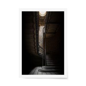 Dimly lit spiral staircase in Old Tbilisi with ornate wrought iron railing and moody architectural details.