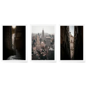 Trio of fine art prints showing the Empire State Building view, ornate spiral staircase, and narrow alley view of a European bell tower, styled for a modern gallery wall.